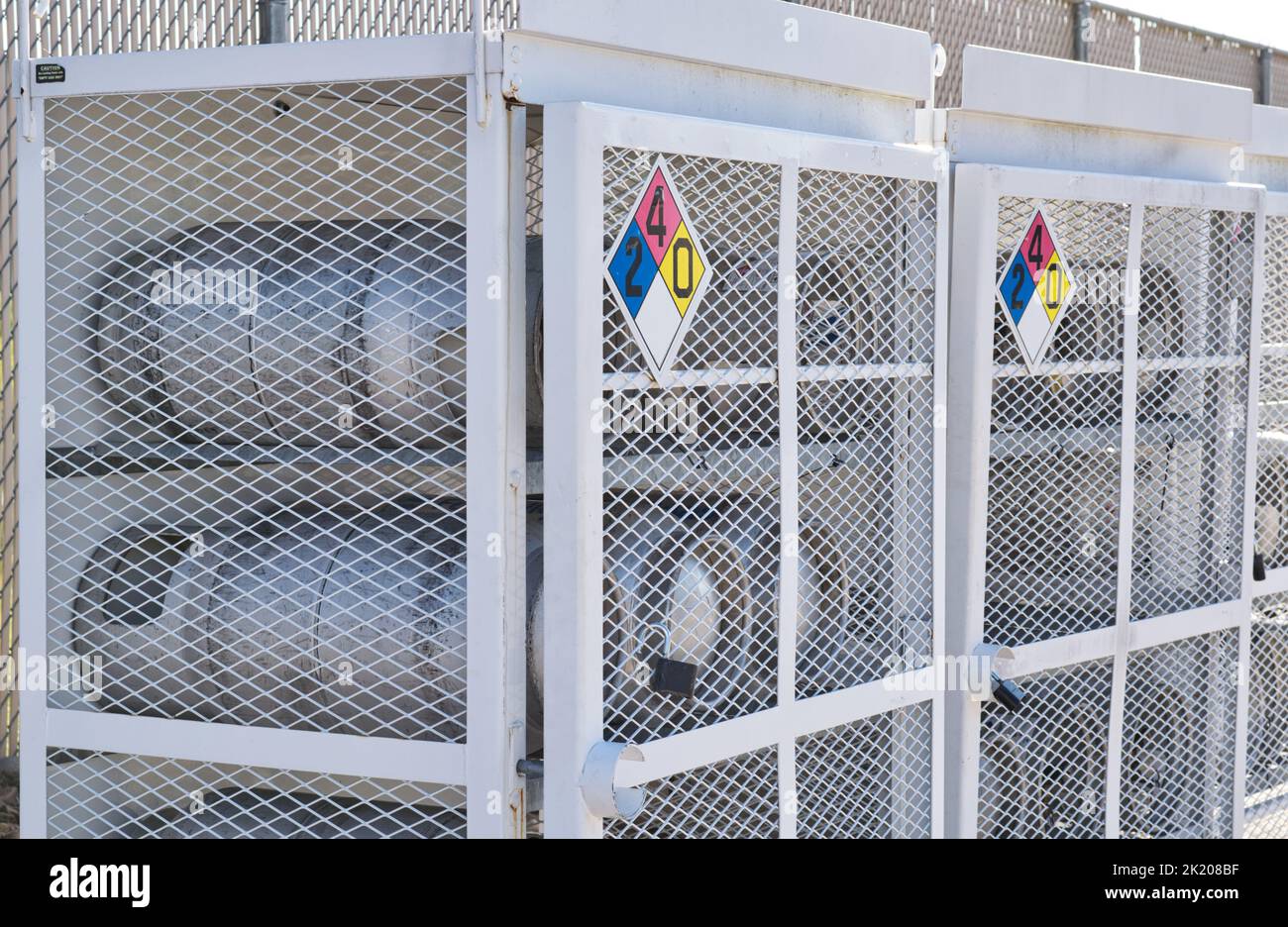 Houston, Texas USA 09-18-2022: Liquid Petroleum gas cylinders stored horizontally in metal safety cages with chemical hazard signs. Stock Photo