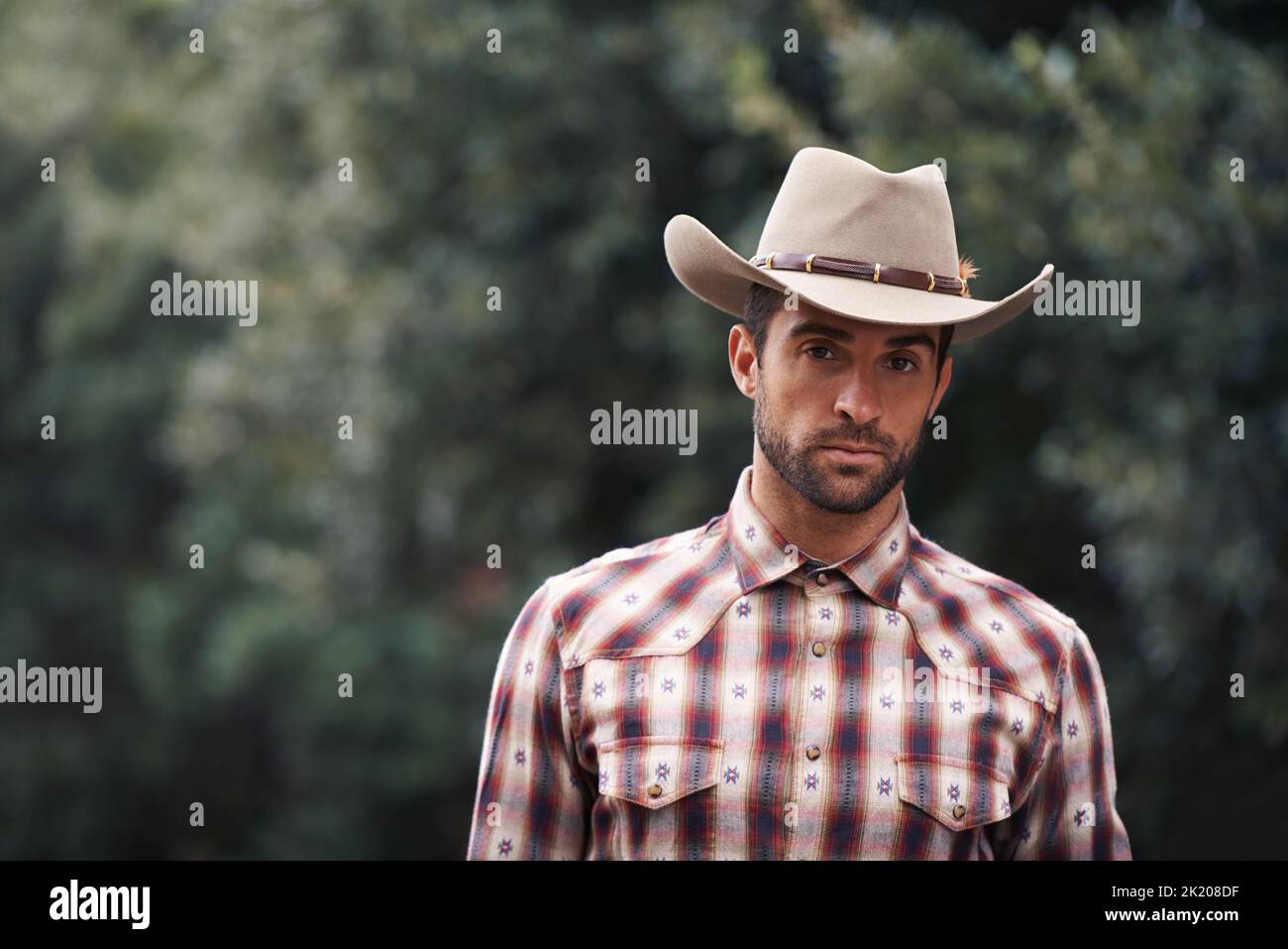 Style will never be plaid out. Portrait of a handsome man wearing a check shirt and cowboy hat. Stock Photo