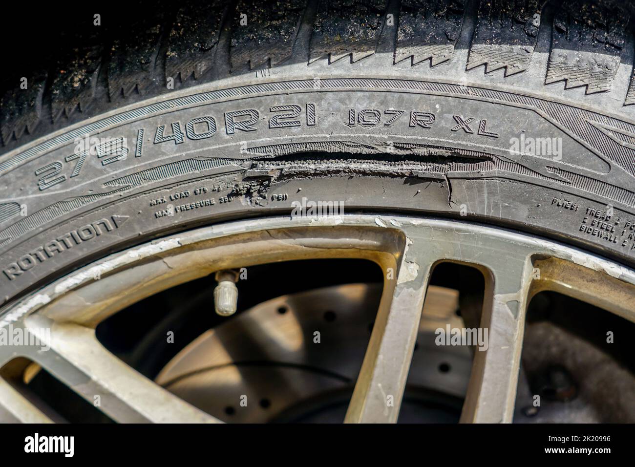 A large long mechanical cut on the sidewall of a passenger car tire, car tyre cut damage Stock