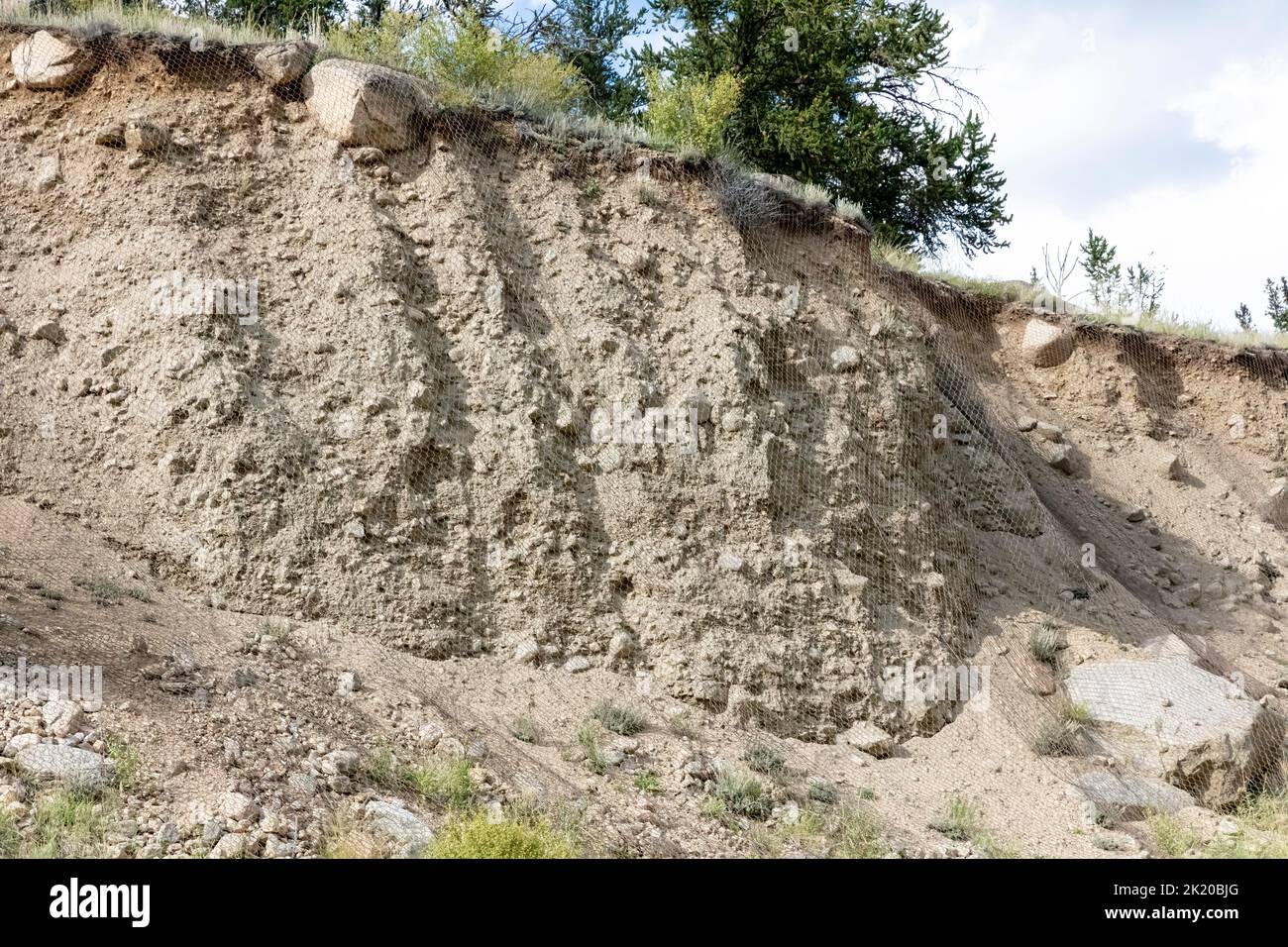 Wire mesh prevents landslide and rock fall along a mountain road in Colorado, USA. Stock Photo