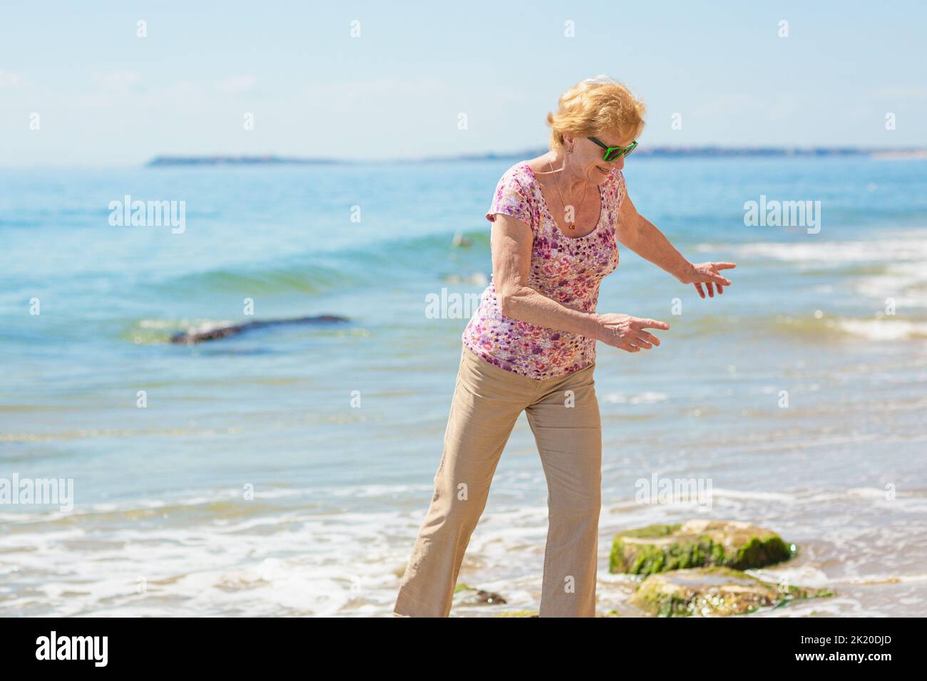 Mature woman enjoying herself on the beach Stock Photo - Alamy