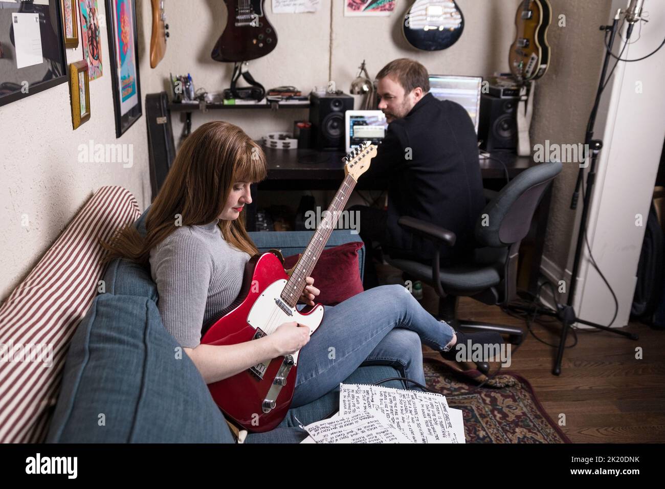 Musician couple playing electric guitar and recording music in studio