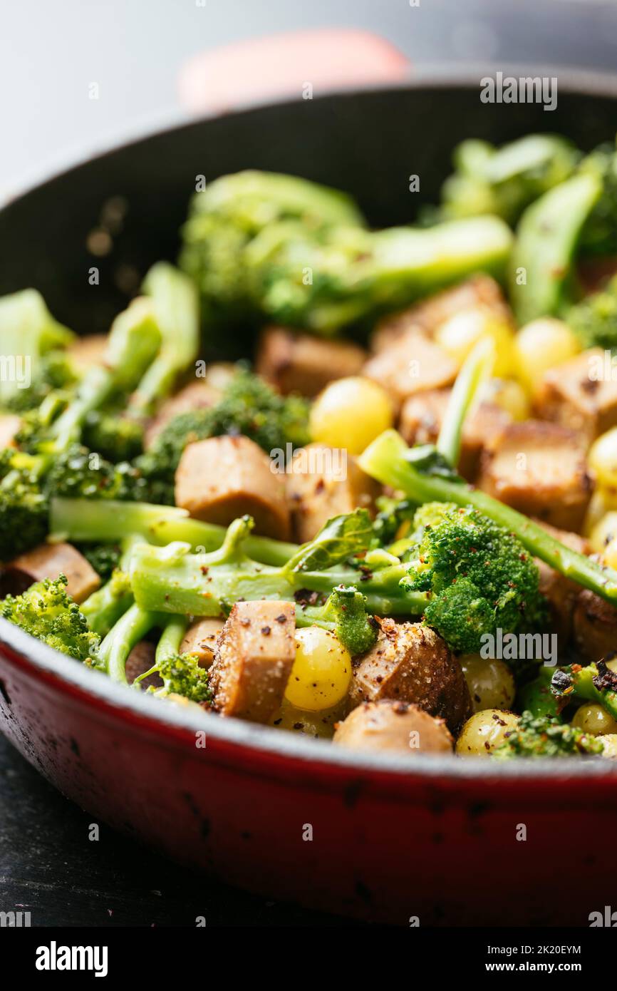 Vegan Sausage with Broccoli and Grapes in a cast iron pan. Stock Photo
