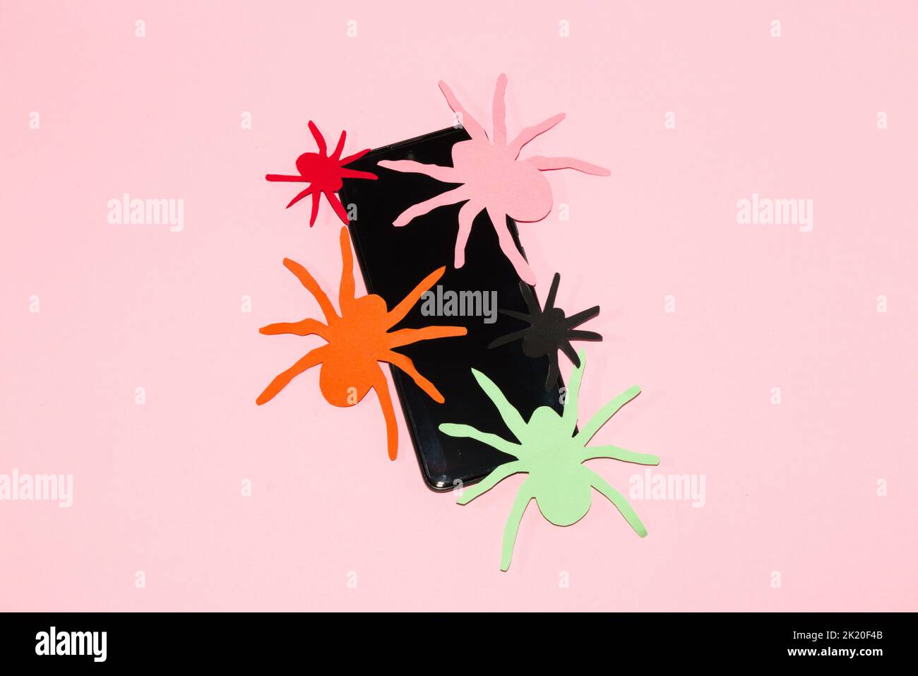 mobile phone with colorful paper spiders, creative halloween concept