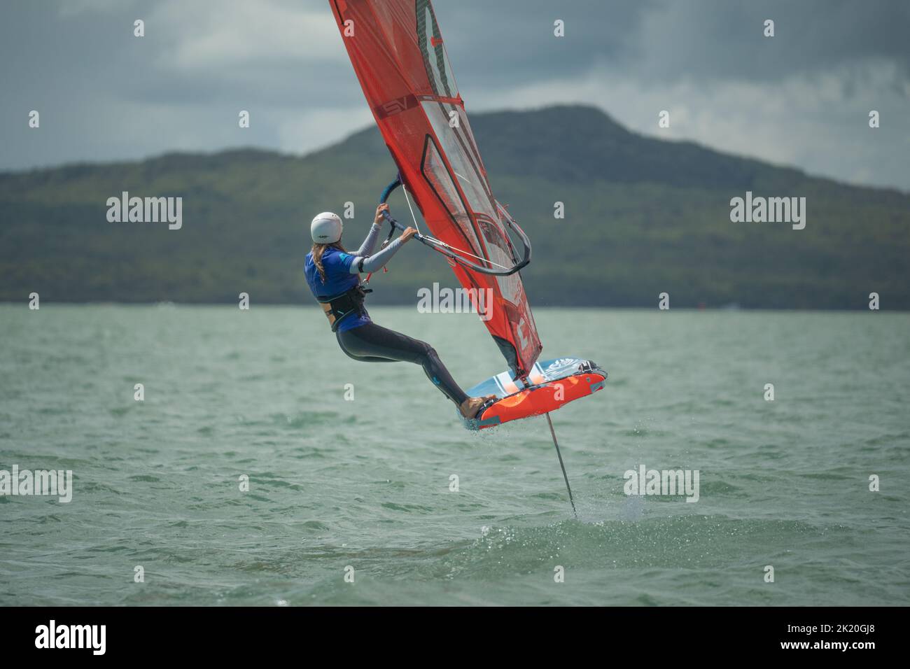 A woman competes in a national windsurfing hydrofoil race at the