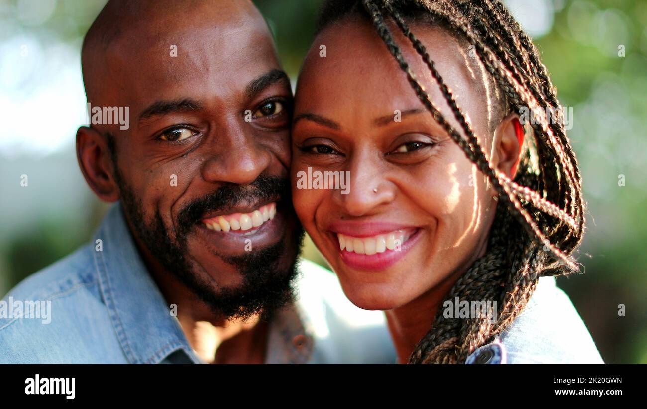 African couple kissing outside, two people smiling at camera Stock