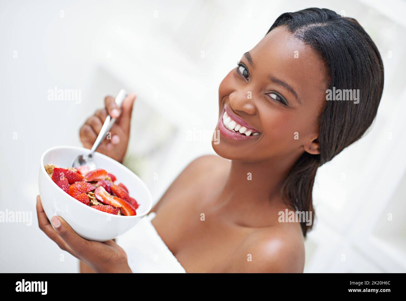 Im starting my morning the strawberry way. a beautiful young woman eating a bowl of strawberriesff. Stock Photo