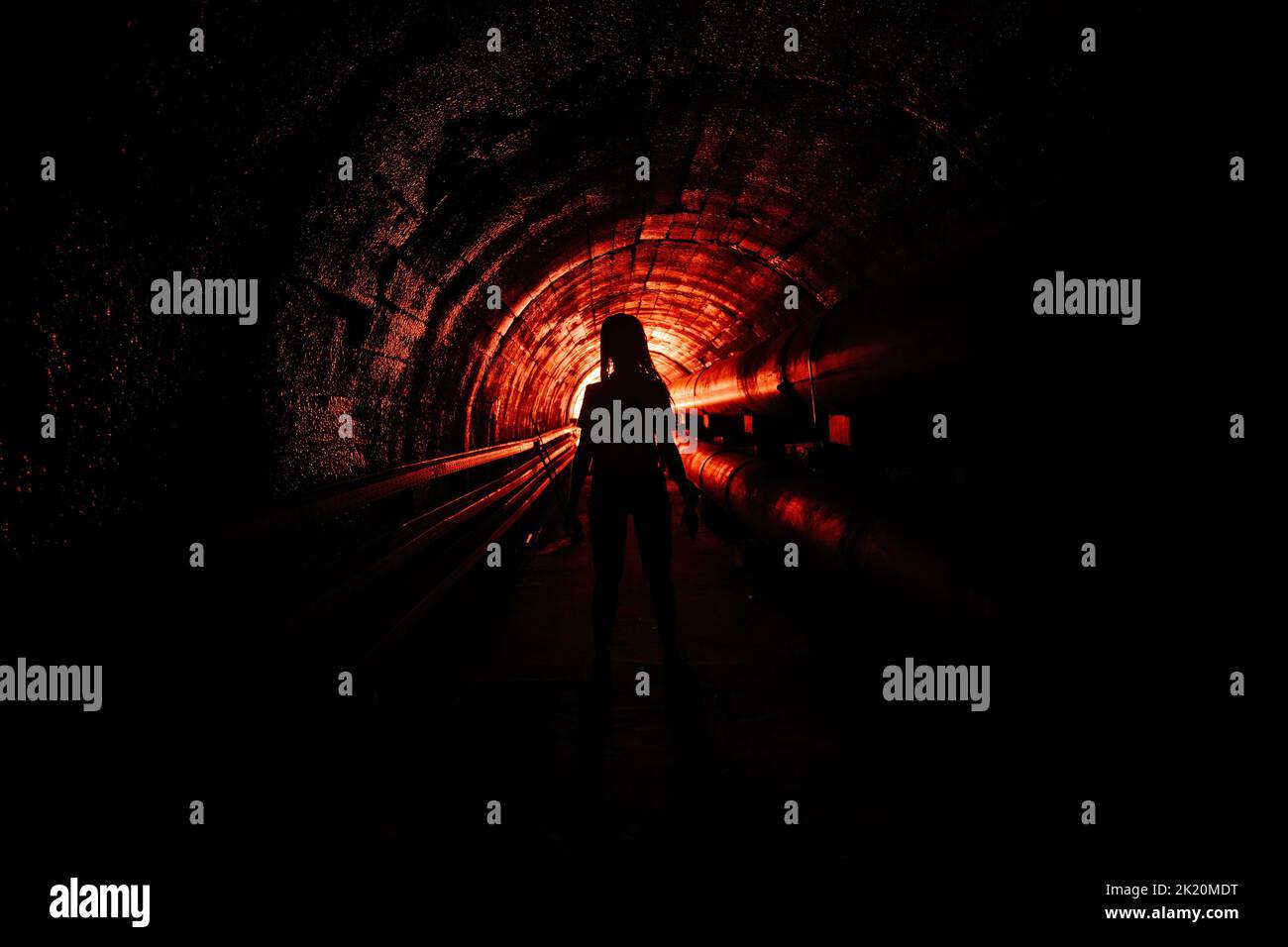Creepy silhouette in the dark underground sewer tunnel. Horror about maniac concept Stock Photo