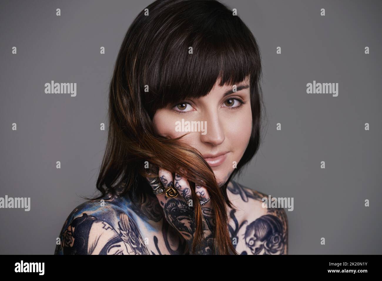 Uniquely beautiful. A cropped studio portrait of a beautiful tattooed young woman. Stock Photo