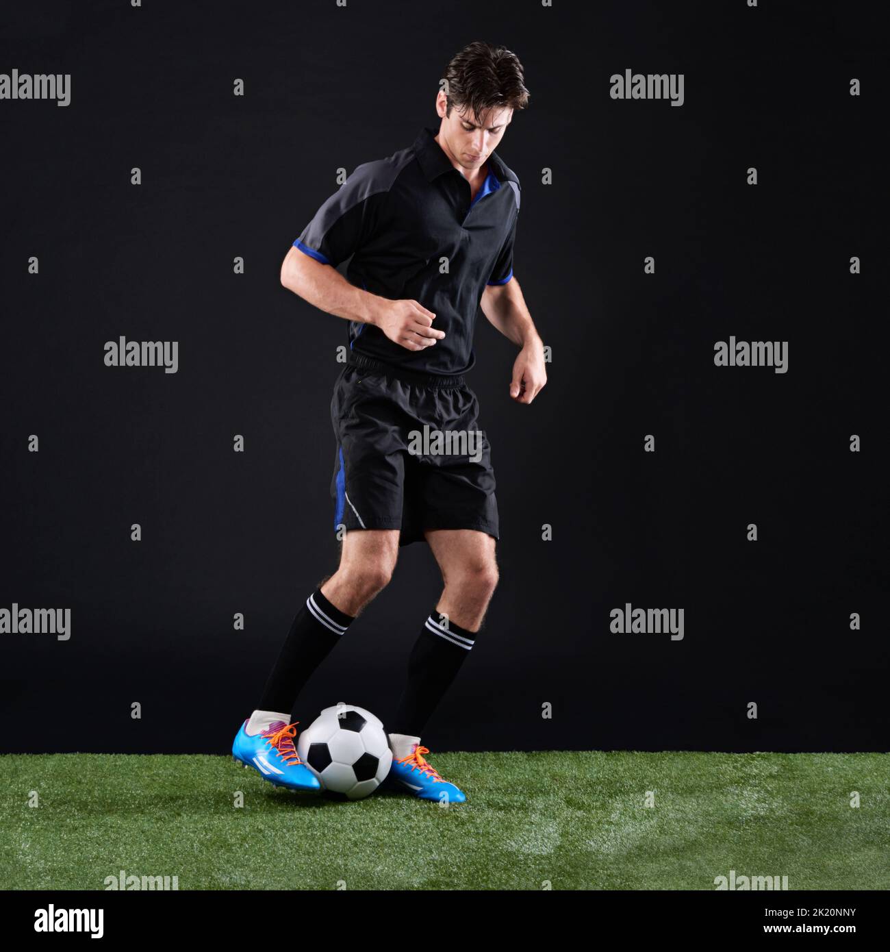 Sports do not build character, they reveal it. Full length studio shot of a handsome young soccer player isolated on black. Stock Photo
