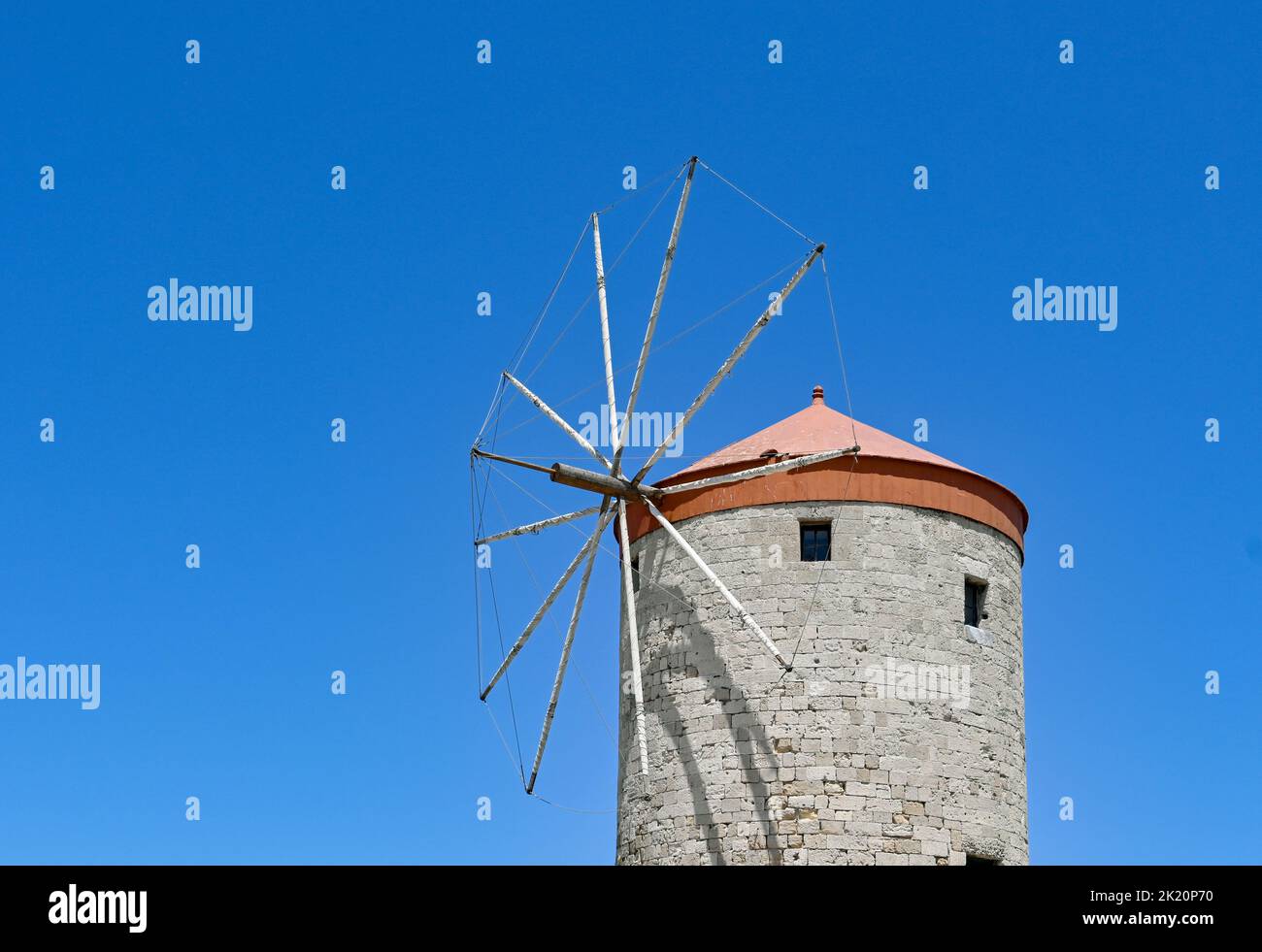 Rhodes, Greece - May 2022: Old windmill isolated against a deep blue sky. No people. Stock Photo