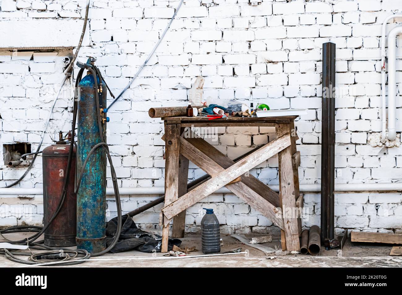 Old gas cylinders for welding and cutting. Rusty propane and oxygen tanks. Tools for metalworking industry. Abandoned construction site. Stock Photo