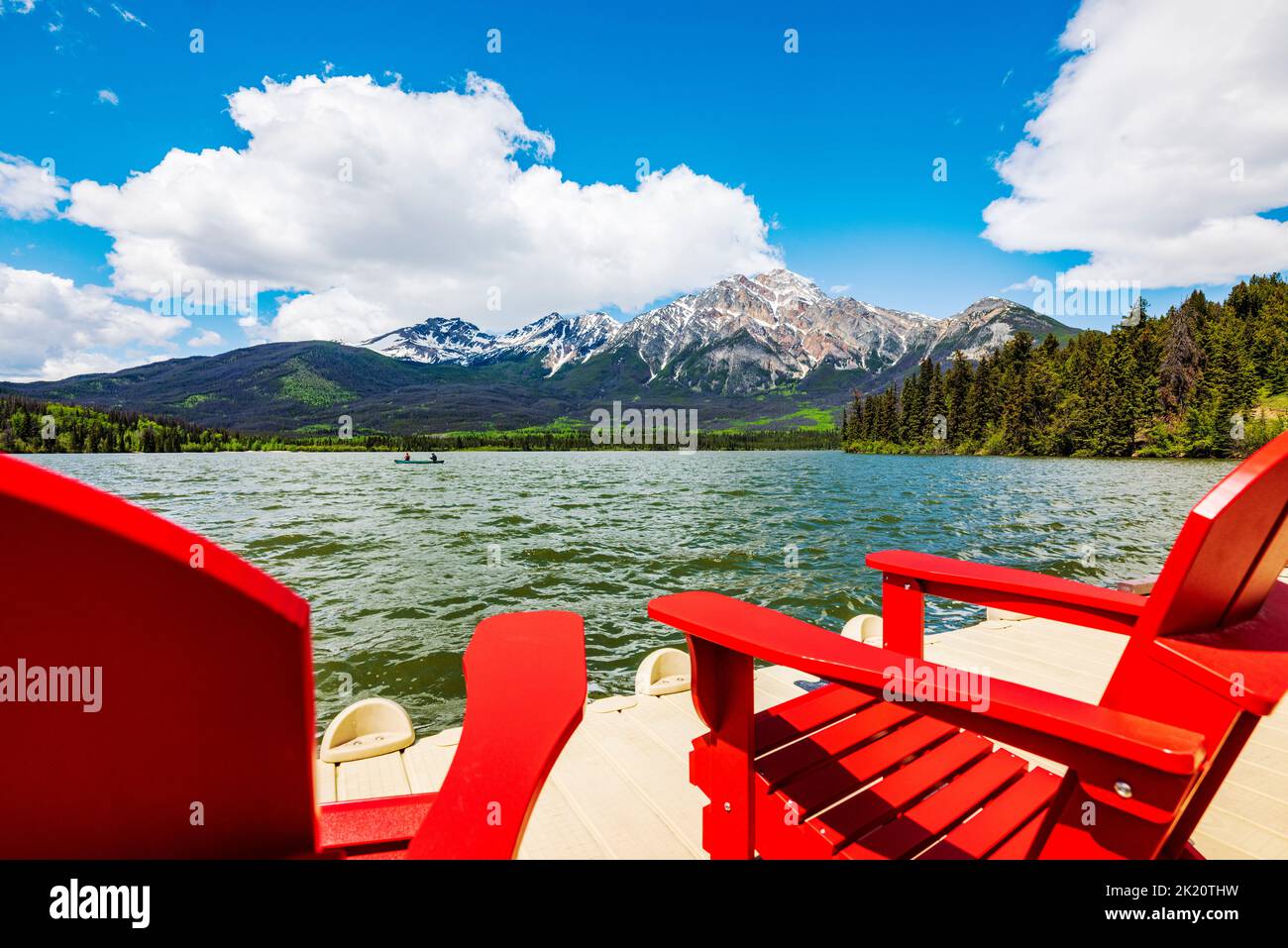 Tourists paddle canoe; dock & Adirondack chairs; Pyramid Lake; Jasper
