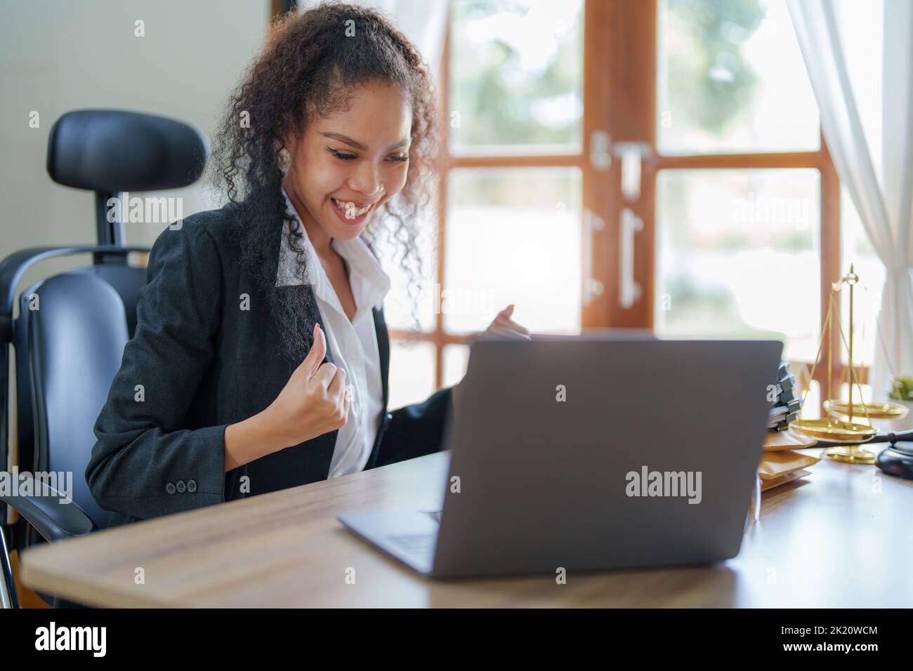female African Americans lawyer showing joy while using a computer Stock Photo
