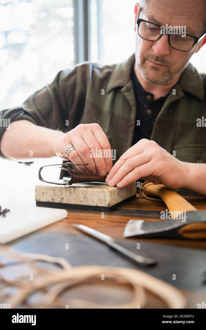 Man leather crafting at home Stock Photo