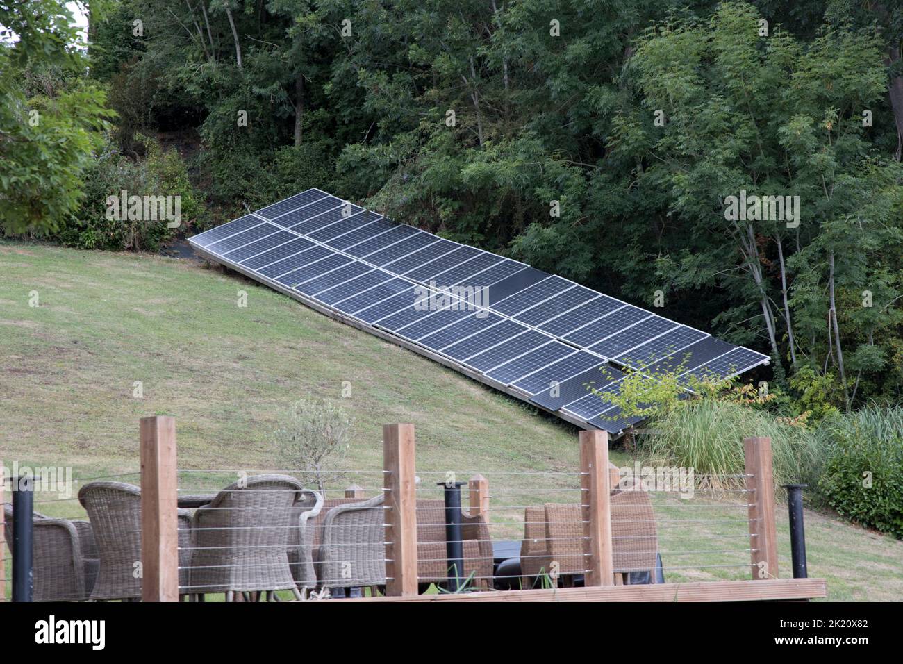 Large array of solar PV panels in private garden in riverside location ...
