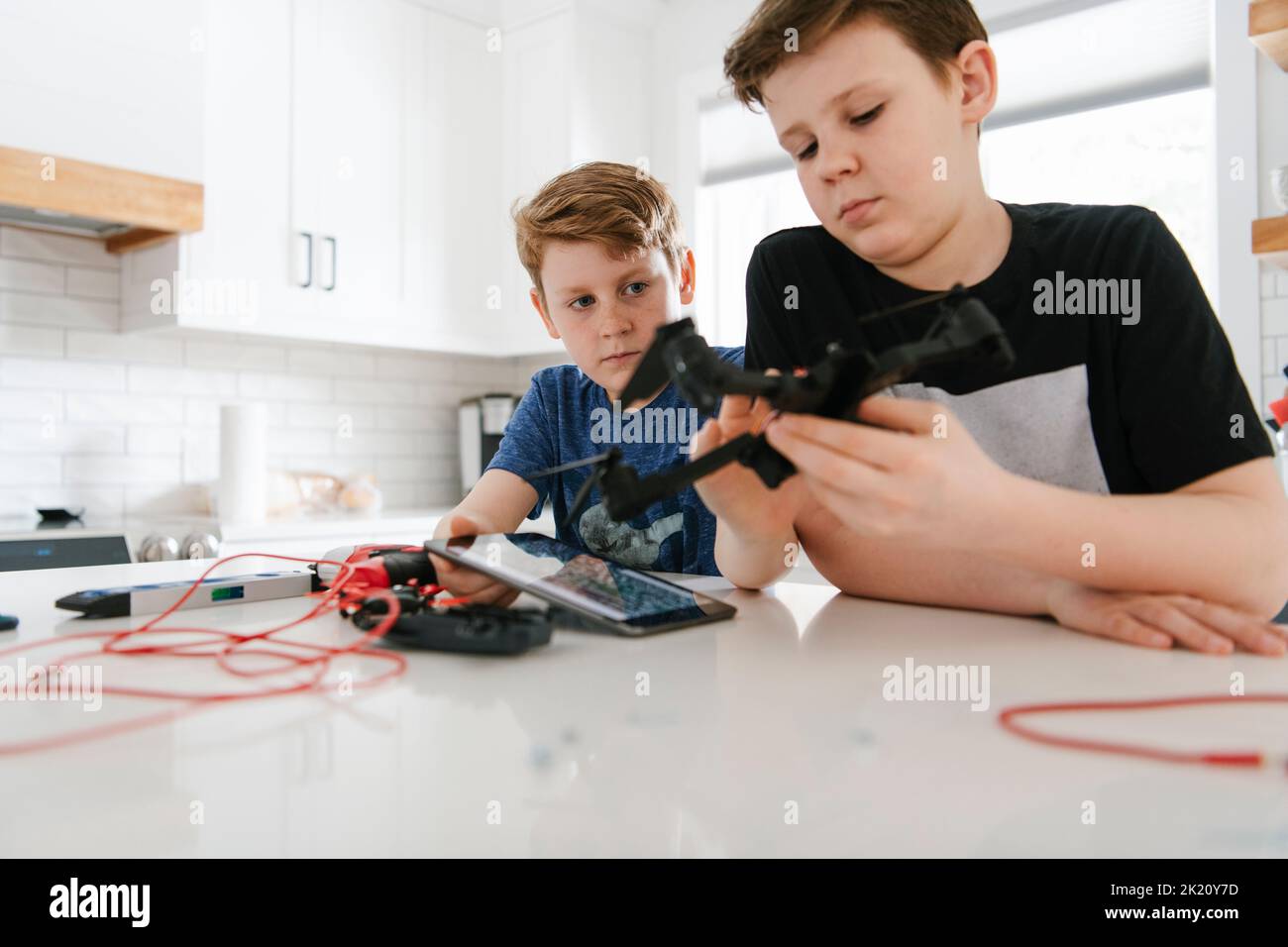 Brothers assembling drone at kitchen counter Stock Photo Alamy