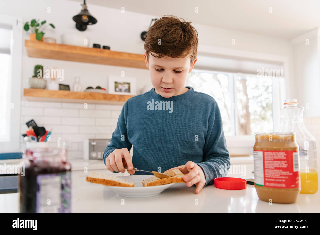 Boy making peanut butter sandwich in kitchen Stock Photo Alamy