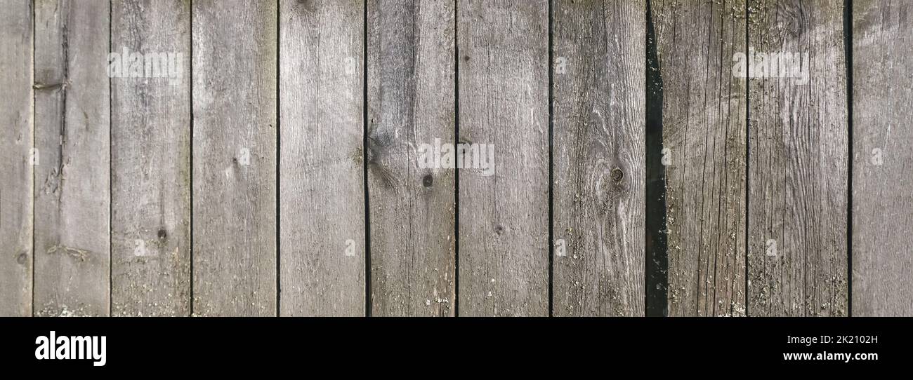 Wooden texture with horizontal lines. The texture of wood with knots and holes. The background of a wooden fence damaged by time. Banner of an old wooden fence. Stock Photo