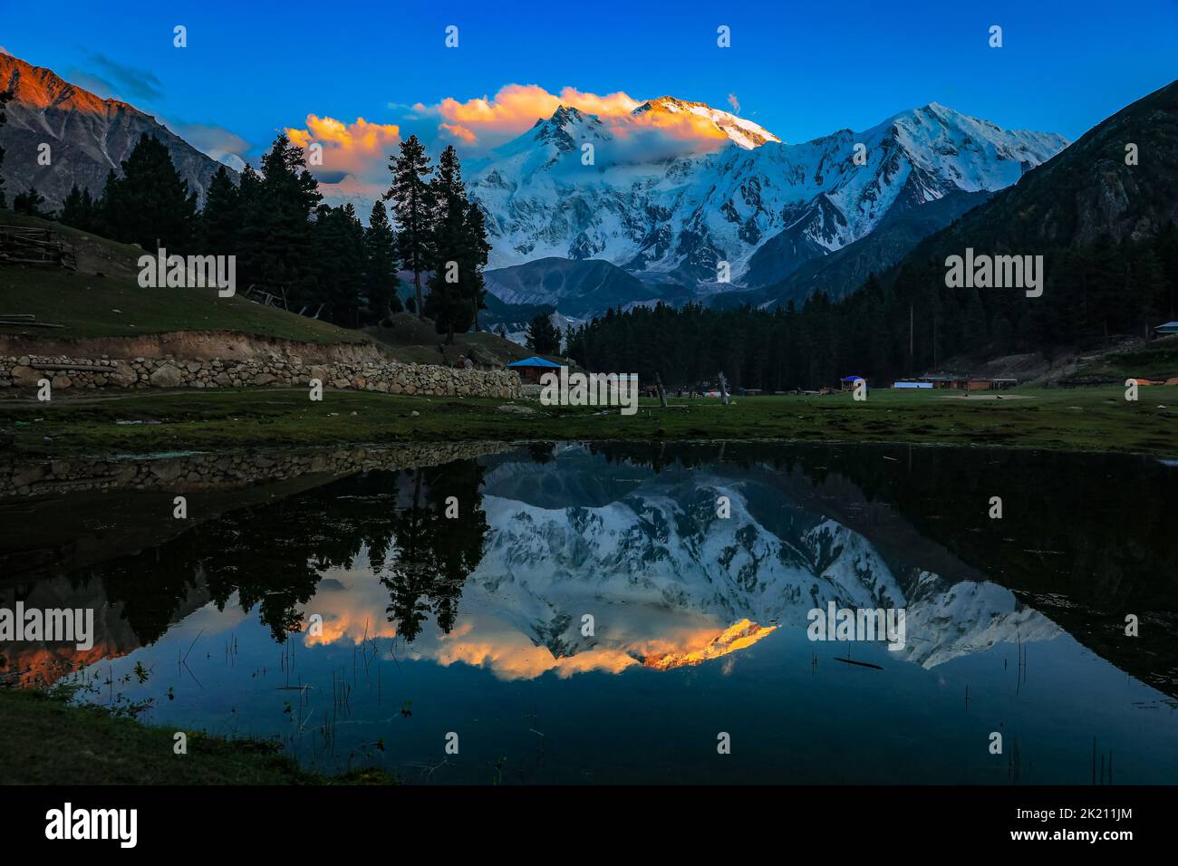 A scenic shot of the Fairy Meadows with the snowy mountains reflected ...