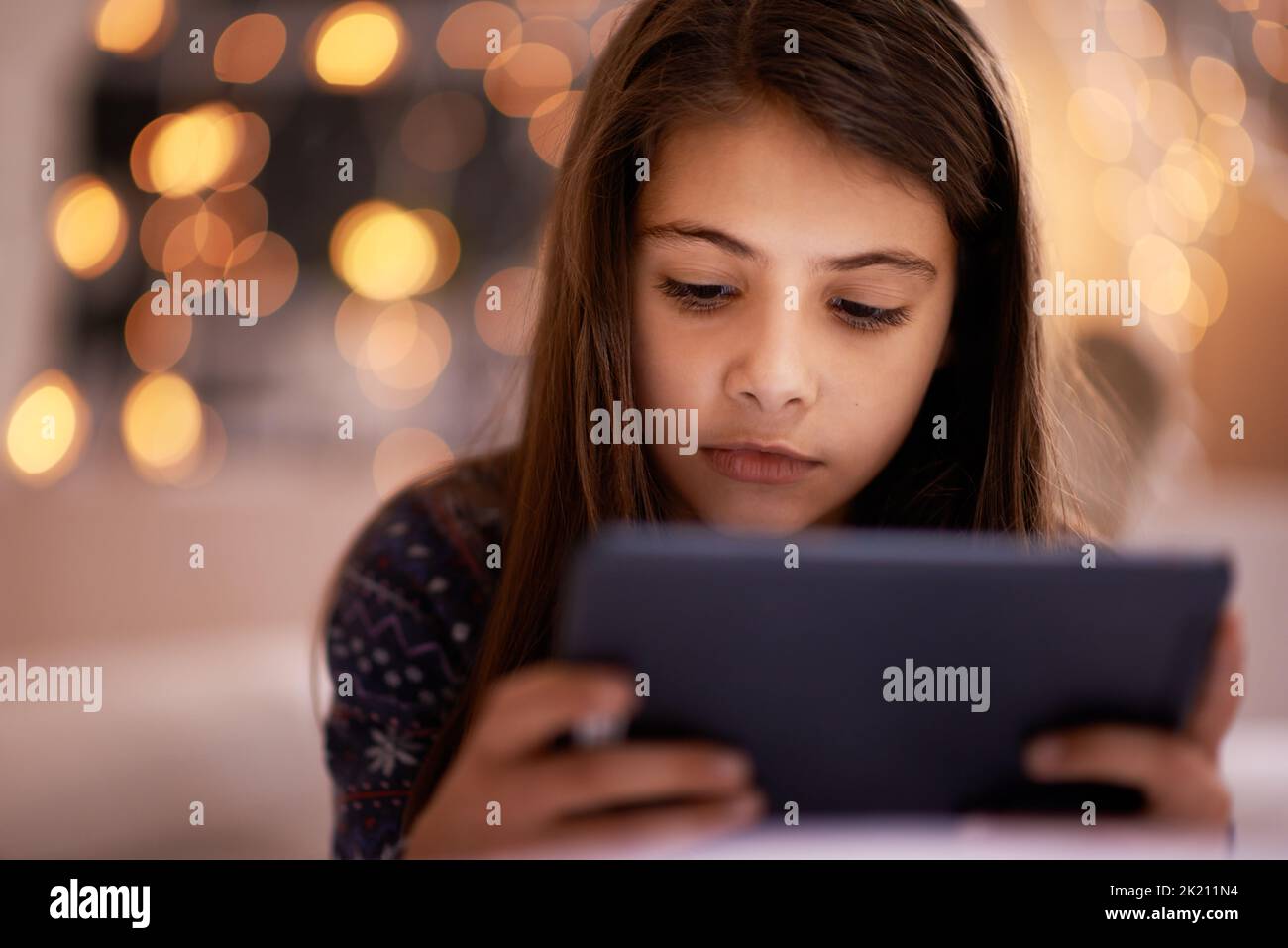 From toys to tablets. a cute little girl using a digital tablet. Stock Photo