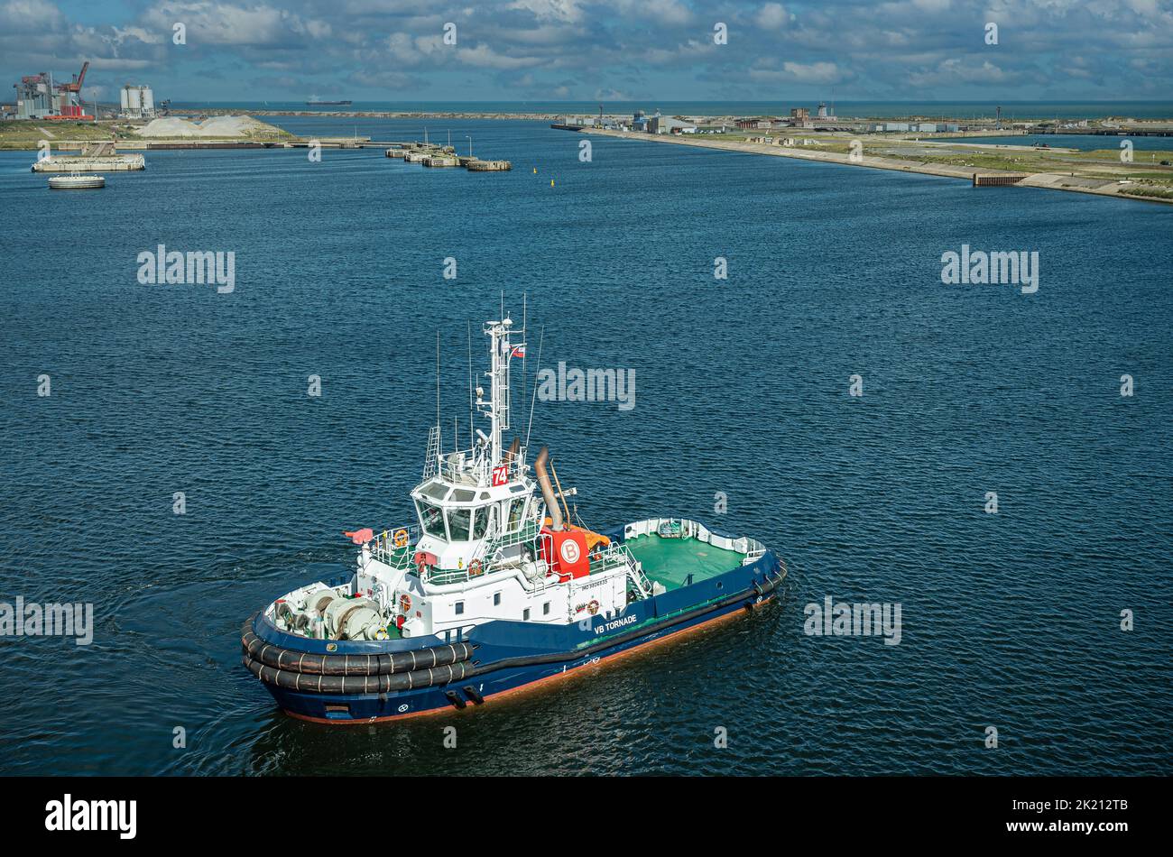 Europe, France, Dunkerque - July 9, 2022: Port scenery. closeup of VB Tornade tugboat on canal de Bourbourg with docks and quays in back Stock Photo