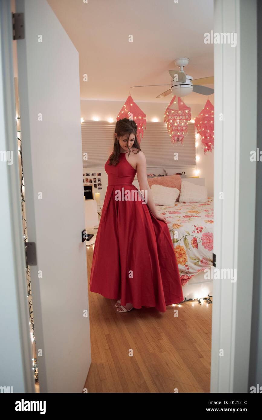 Teenage girl in red prom dress in bedroom Stock Photo Alamy