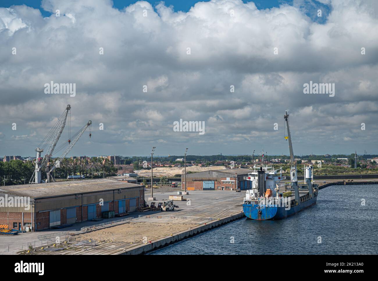 Europe, France, Dunkerque - July 9, 2022: Port scenery. Blue-white Challenger general cargo ship with its own cranes docked on quay 5 under thick clou Stock Photo