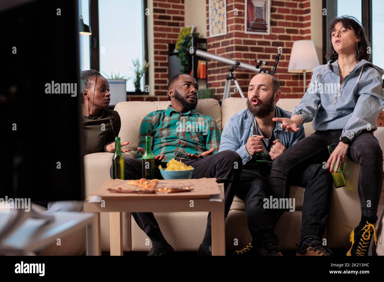 Group of supporters feeling sad about lost football game match, drinking beer at hangout. Watching soccer team losing championship tournament, being frustrated and angry about lose. Stock Photo