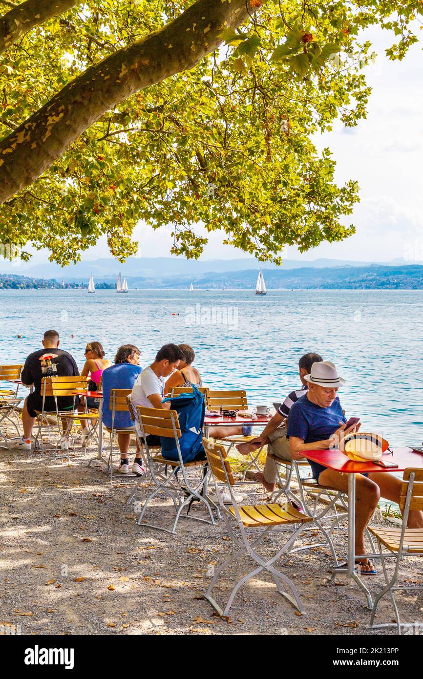 People sitting al fresco at a cafe in Zürichhorn overlooking Lake Zurich, Zurich, Switzerland Stock Photo