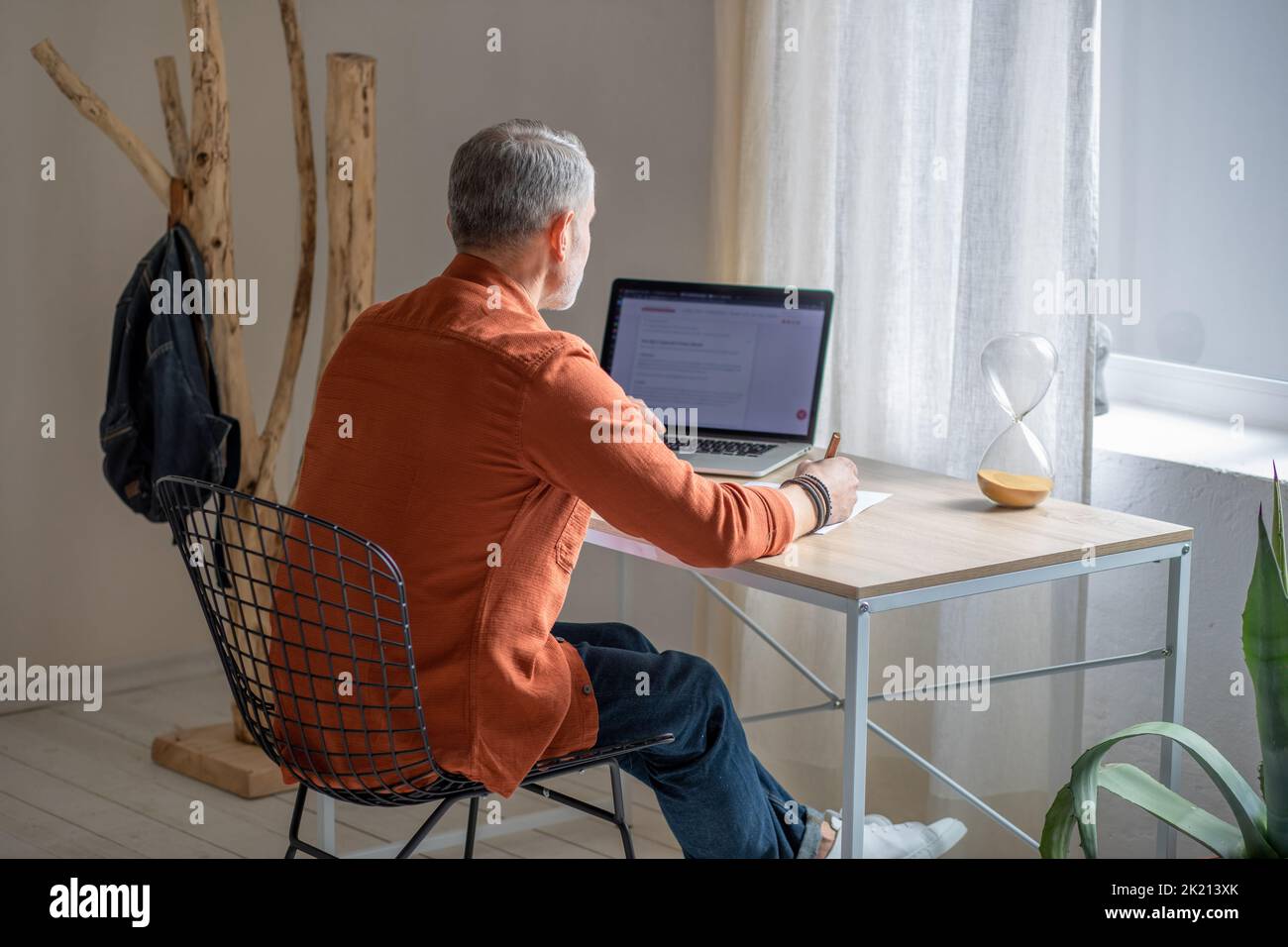 Manager sitting at the table in the office and looking thoughtful Stock Photo