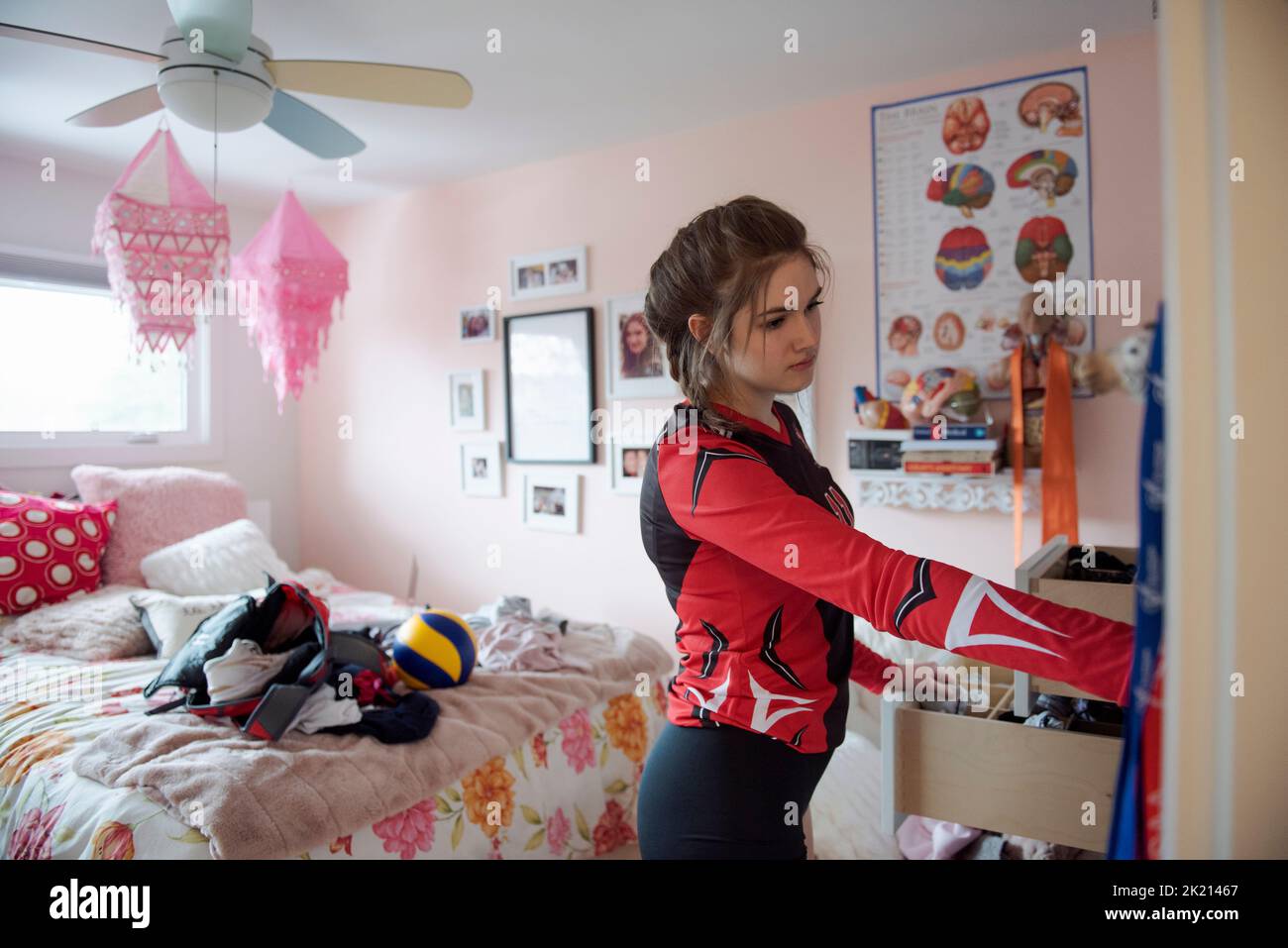 Teenage girl in sports uniform getting dressed in bedroom Stock Photo ...