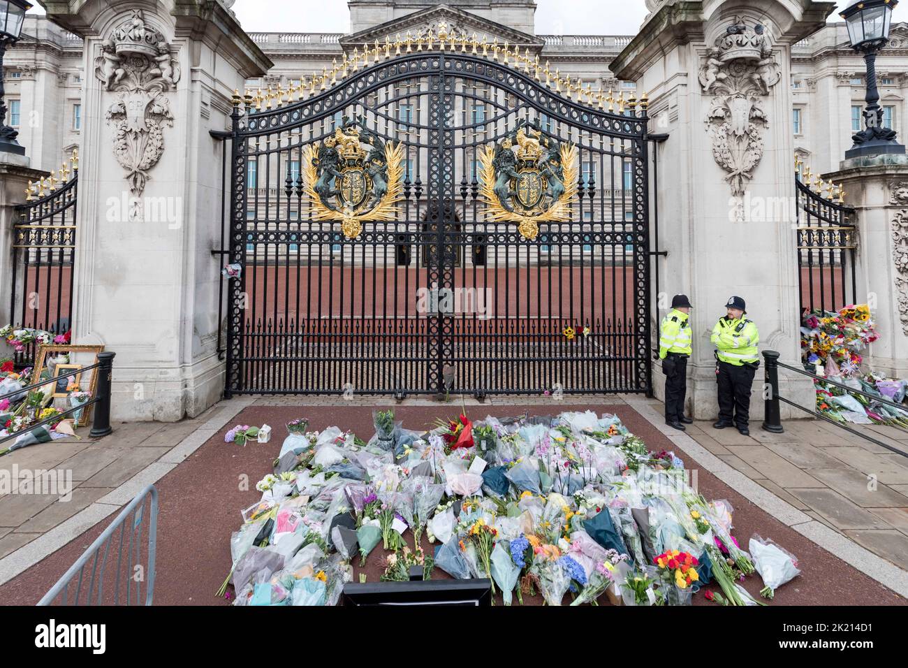 People lay flowers and wreaths in front of the gates of Buckingham Palace this morning