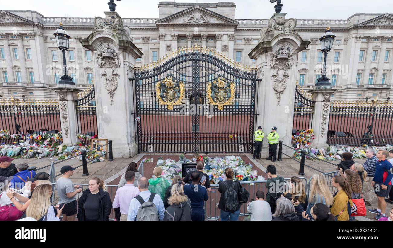 People lay flowers and wreaths in front of the gates of Buckingham Palace this morning