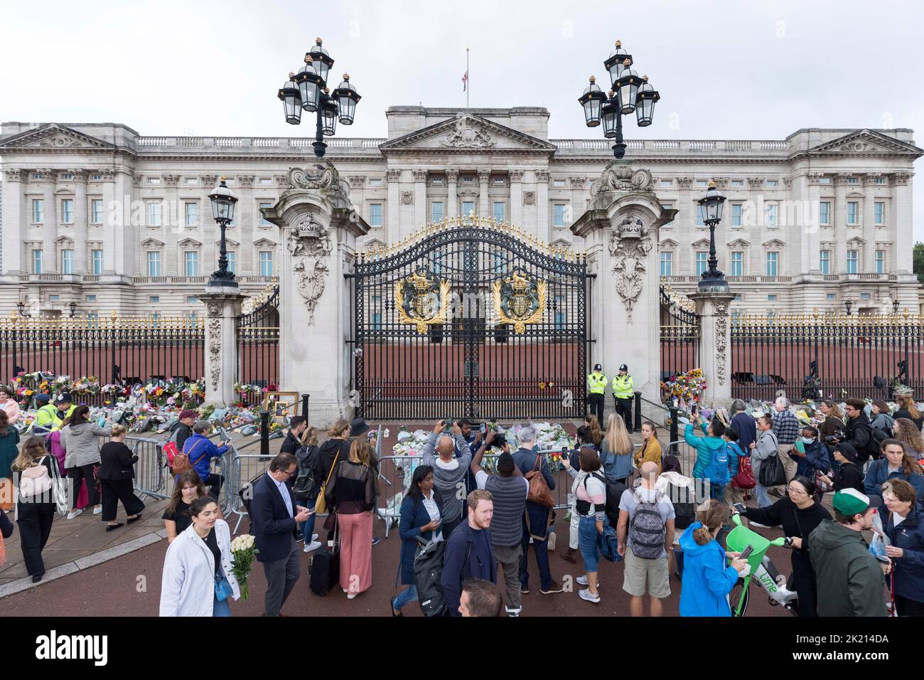 People lay flowers and wreaths in front of the gates of Buckingham Palace this morning