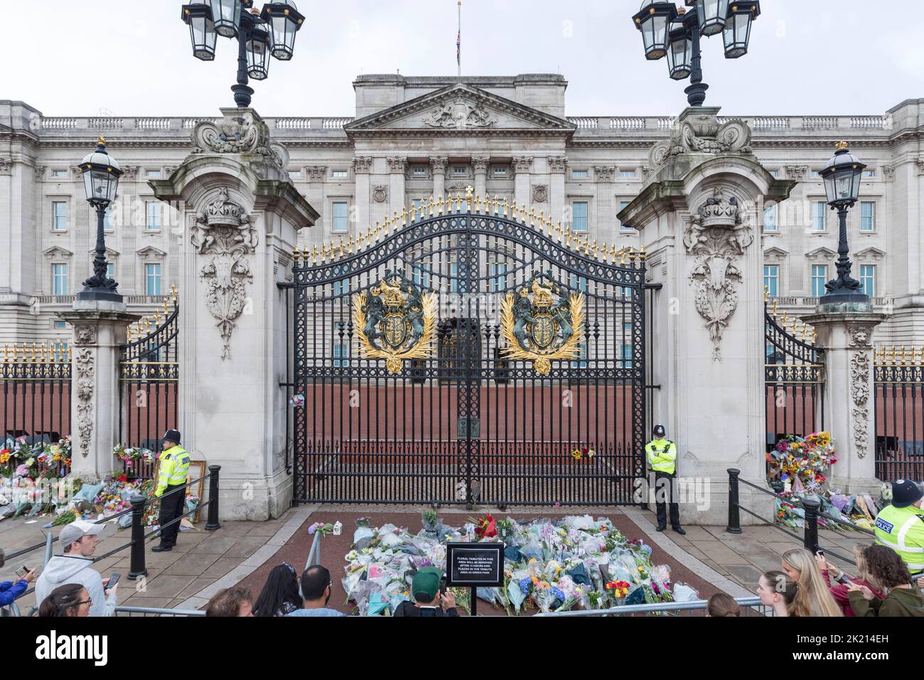 People lay flowers and wreaths in front of the gates of Buckingham Palace this morning
