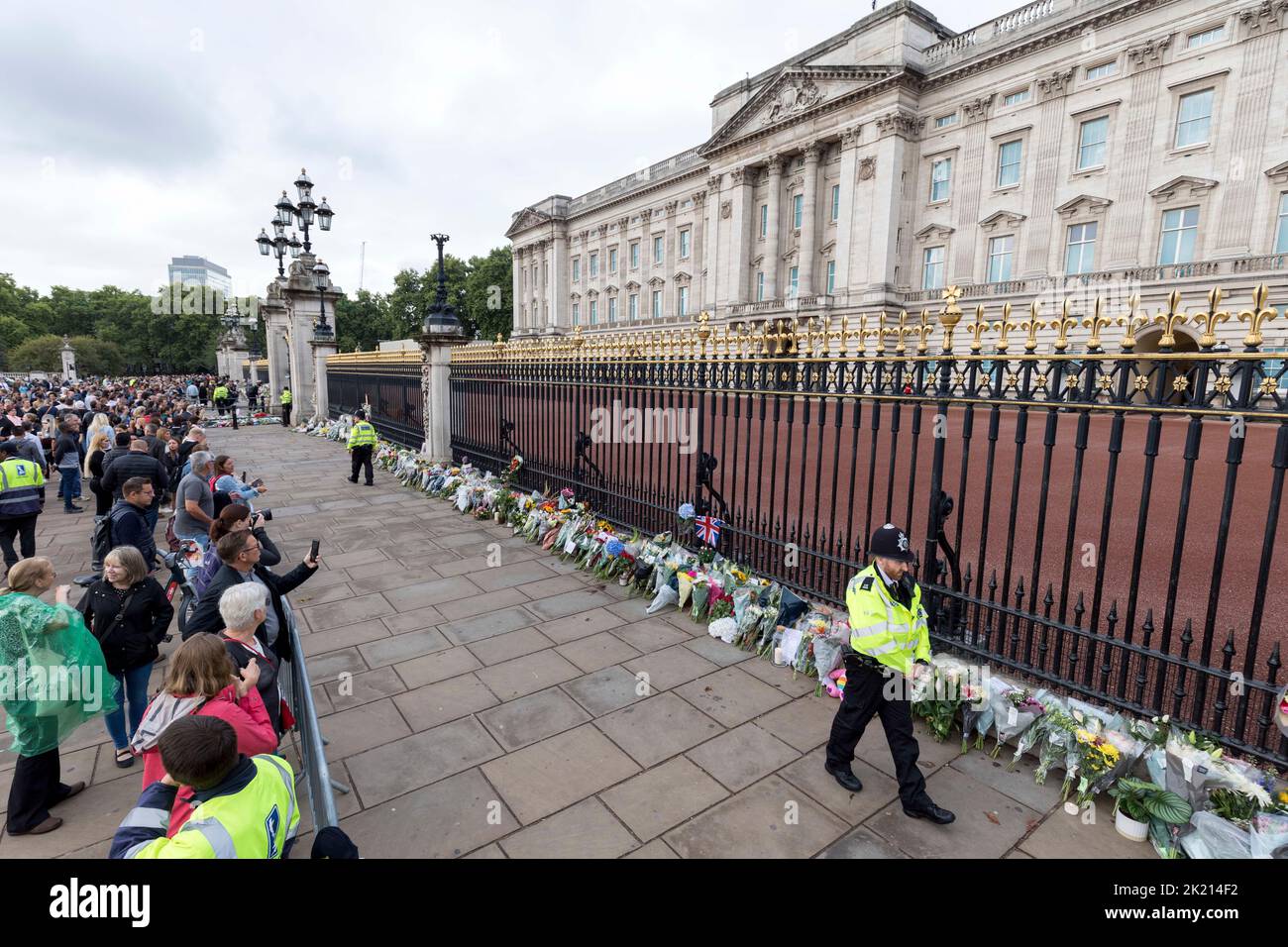 People lay flowers and wreaths in front of the gates of Buckingham