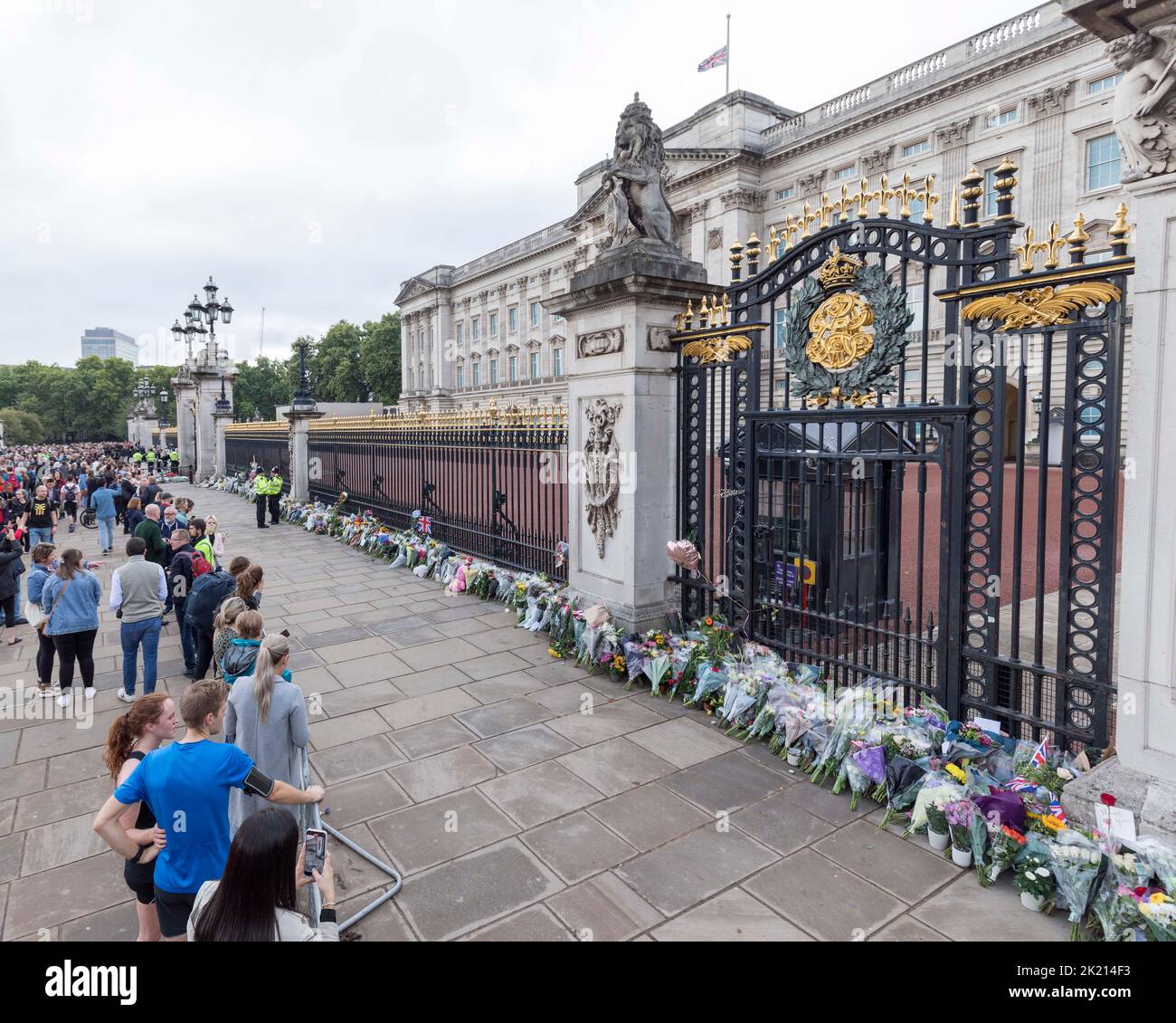 People lay flowers and wreaths in front of the gates of Buckingham