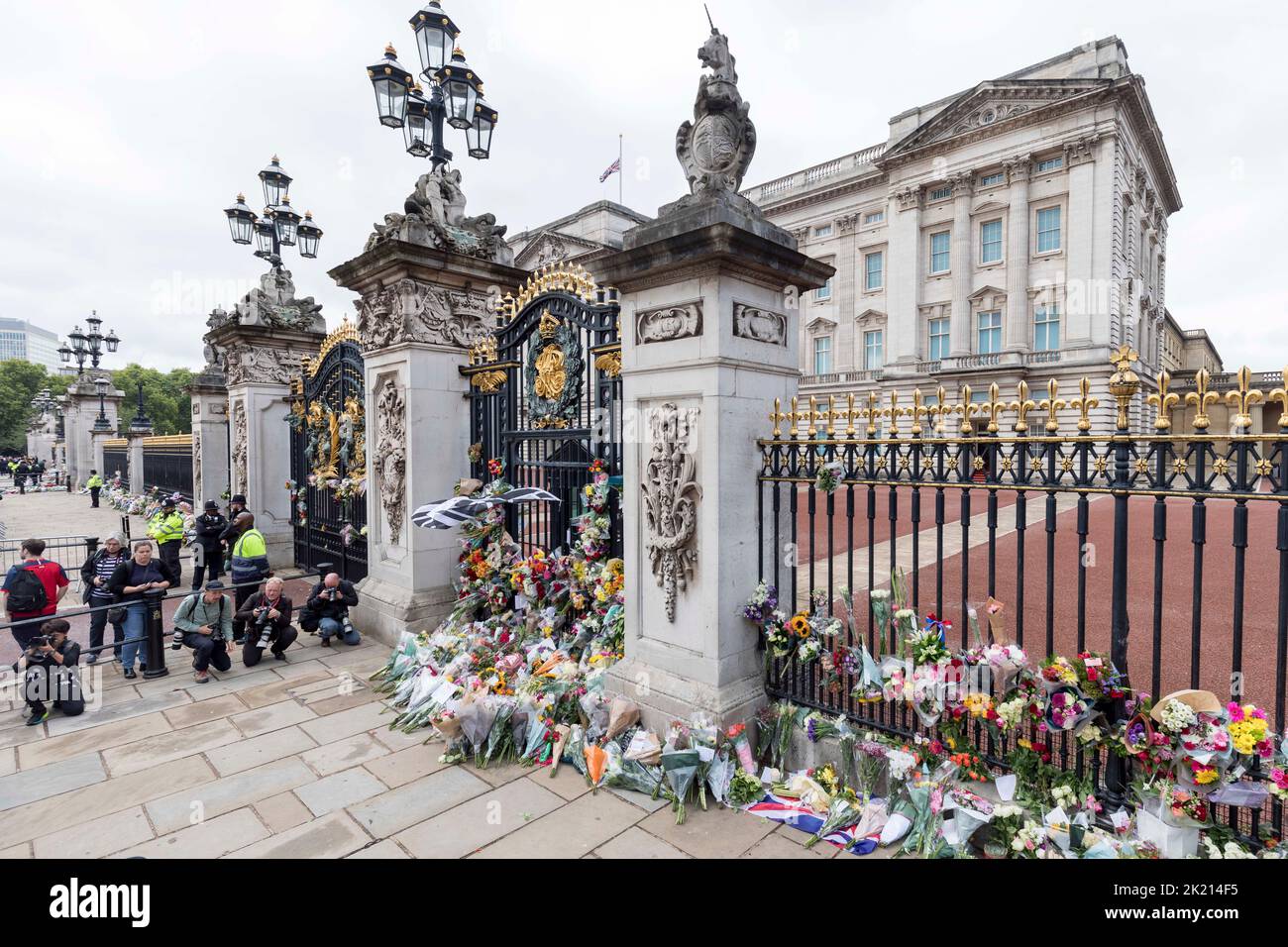 People lay flowers and wreaths in front of the gates of Buckingham Palace this morning