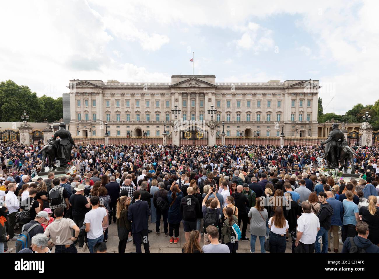 People lay flowers and wreaths in front of the gates of Buckingham