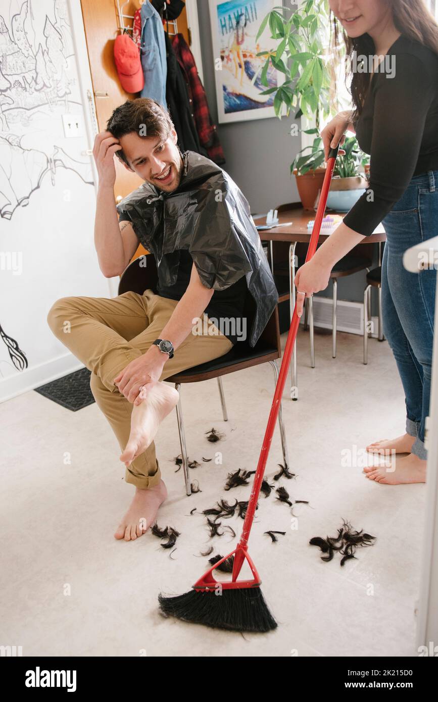 Woman sweeping hair on kitchen floor Stock Photo Alamy