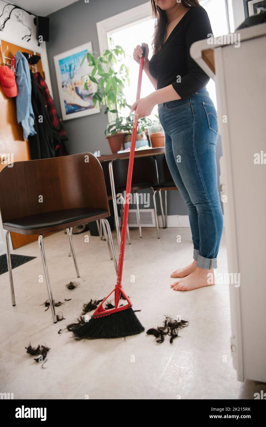 Woman sweeping hair on kitchen floor Stock Photo Alamy