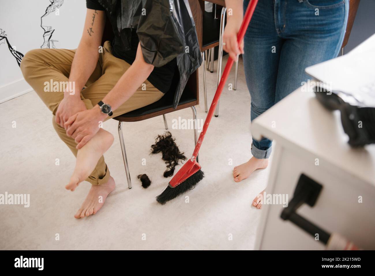 Woman sweeping hair on kitchen floor Stock Photo Alamy
