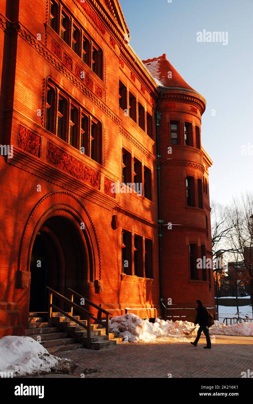 A student heads towards the entrance of Sever hall on Harvard Yard on a cold winter day on the Harvard University campus in Cambridge Stock Photo