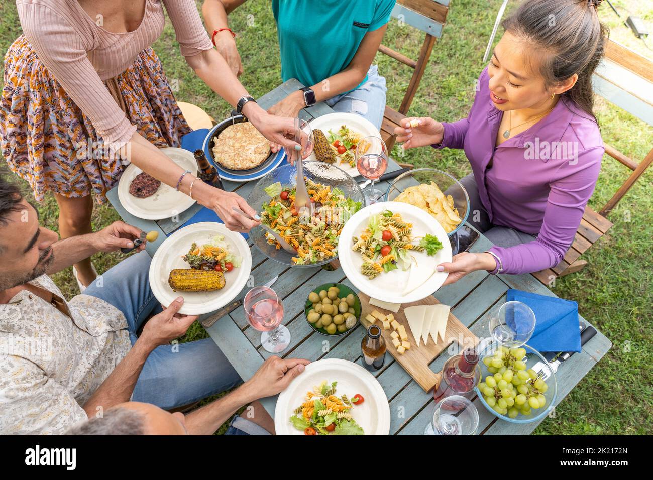 Top view of people serving food and drinks in a wooden teal table