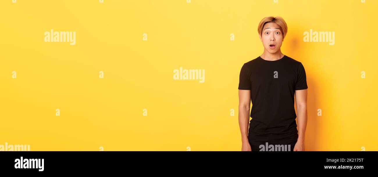 Portrait of startled handsome asian blond guy, drop jaw and gasping