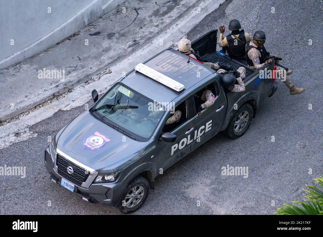 A group of Haitian policemen in full tactical gear, piled up in a black PNH pickup truck, on their way to clear the barricades and manifestations in P Stock Photo