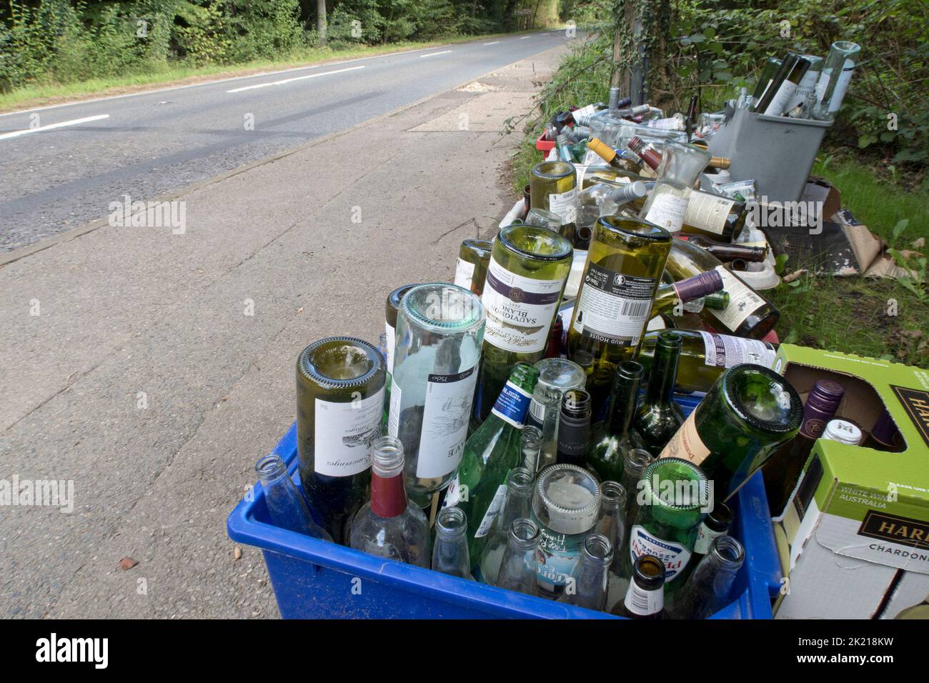 containers of glass bottles by roadside awaiting collection Stock Photo