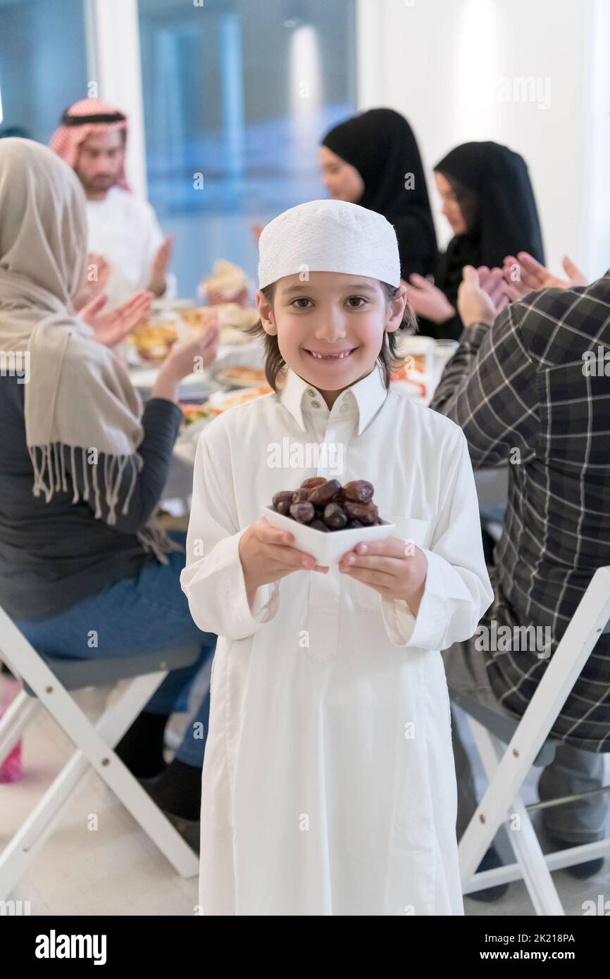 Eid Mubarak Muslim family having Iftar dinner little boy holding a