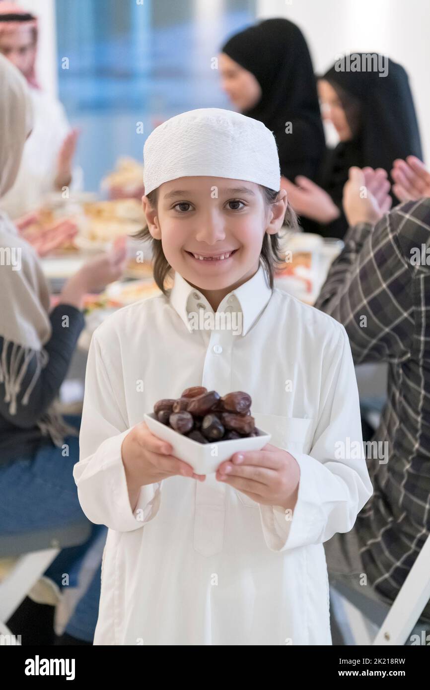 Eid Mubarak Muslim family having Iftar dinner little boy holding a